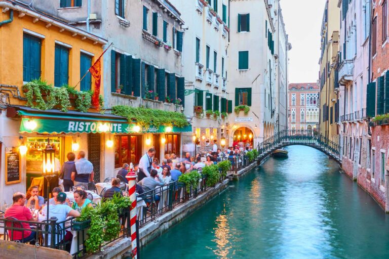 People at restaurant near canal in Venice